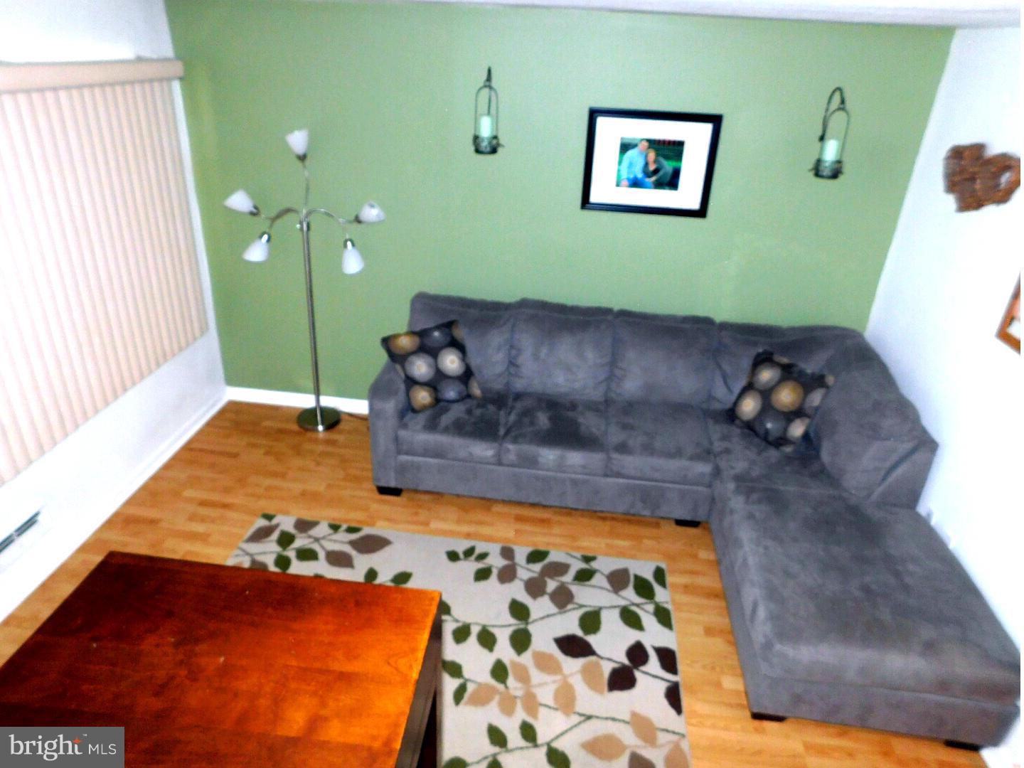 7708 Charlesmont Road Baltimore, MD 21222 - Photo 2 of 28 a living room with a couch and a rug