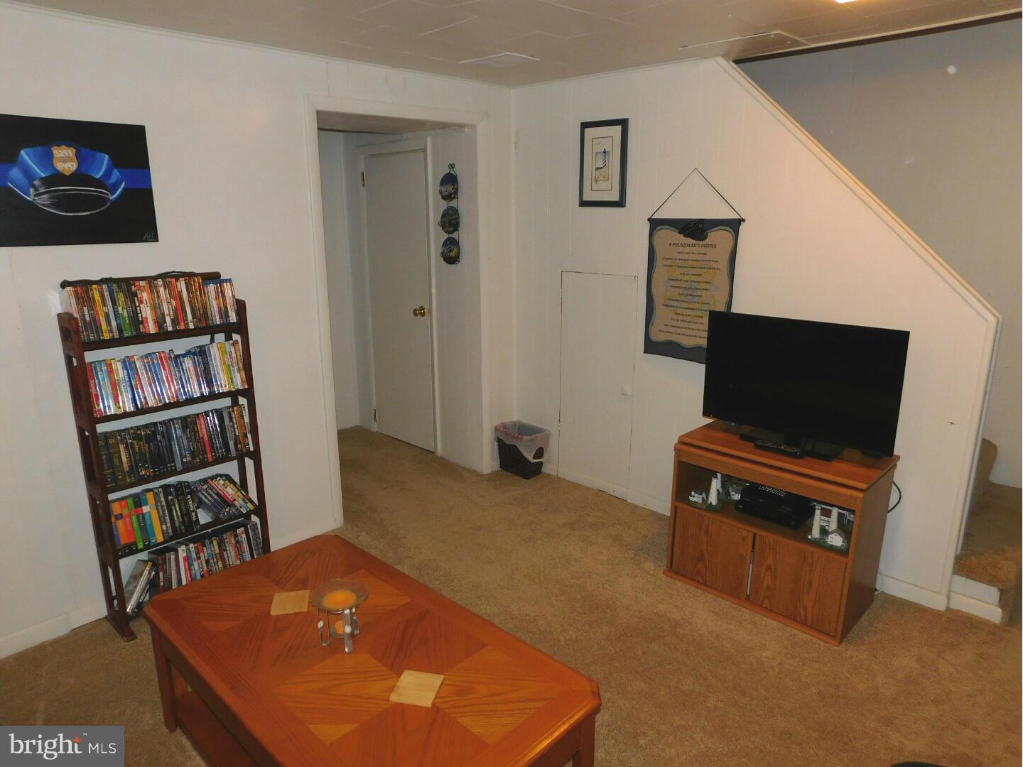 7708 Charlesmont Road Baltimore, MD 21222 - Photo 21 of 28 a living room with computer on a table and bookshelf