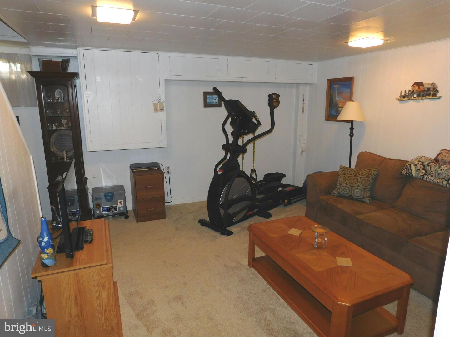 7708 Charlesmont Road Baltimore, MD 21222 - Photo 22 of 28 a room with furniture a mirror and gym equipment