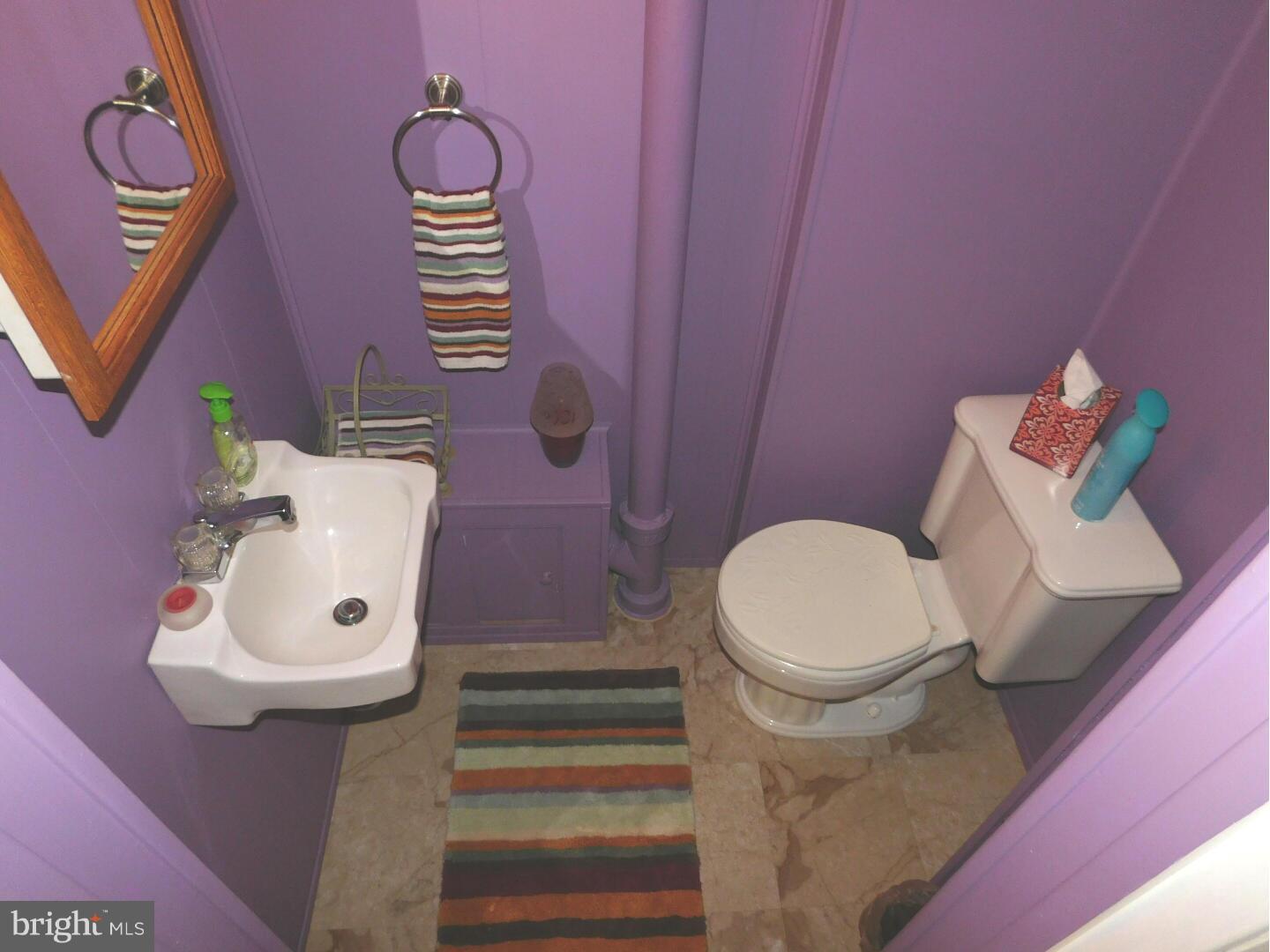 7708 Charlesmont Road Baltimore, MD 21222 - Photo 23 of 28 a bathroom with a toilet a sink and mirror