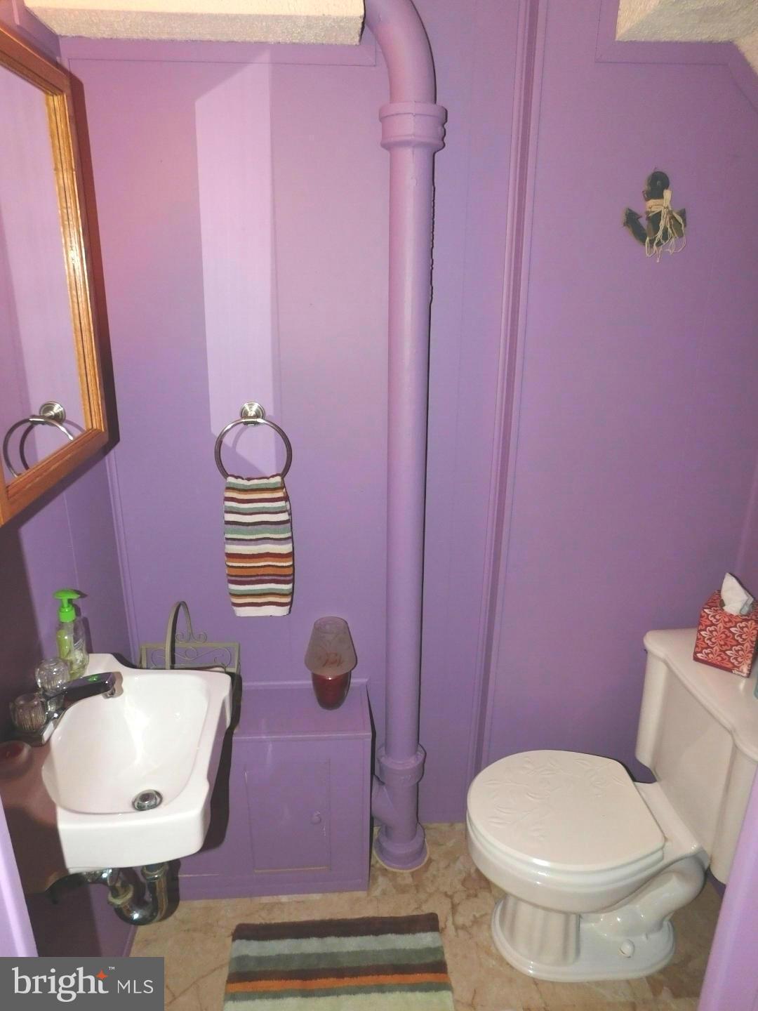 7708 Charlesmont Road Baltimore, MD 21222 - Photo 24 of 28 a bathroom with a toilet a sink and a mirror