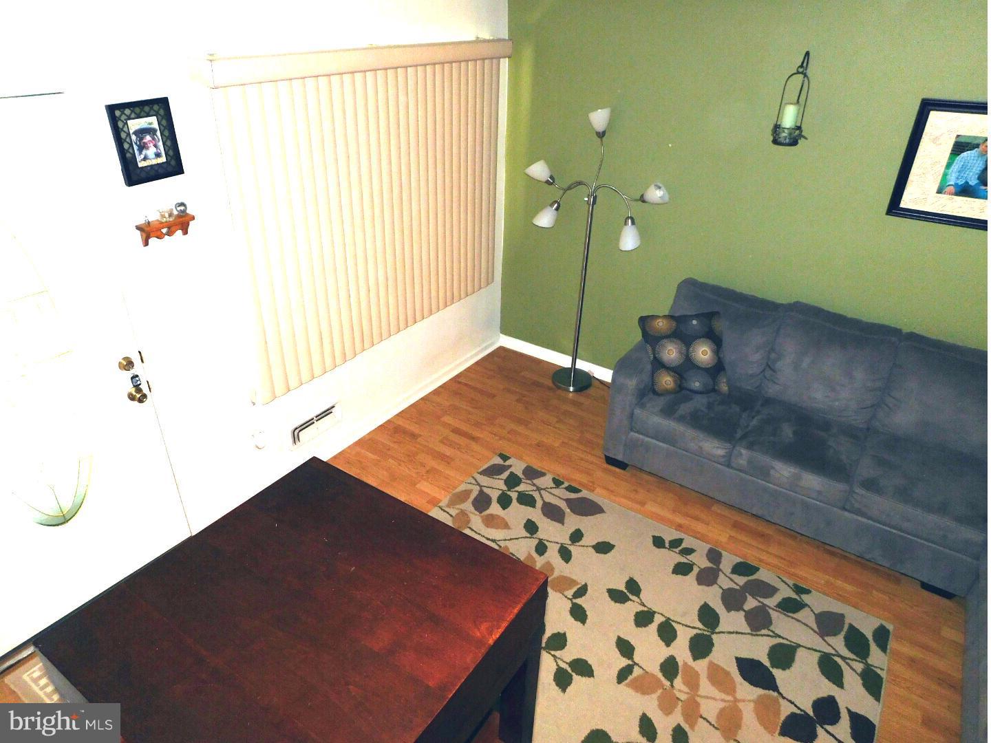 7708 Charlesmont Road Baltimore, MD 21222 - Photo 4 of 28 a living room with a couch and a potted plant