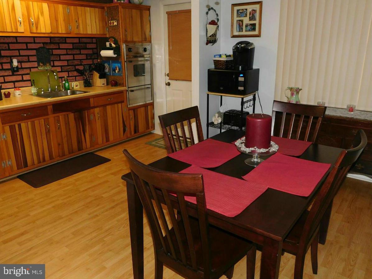 7708 Charlesmont Road Baltimore, MD 21222 - Photo 8 of 28 a view of a dining room with furniture window and wooden floor
