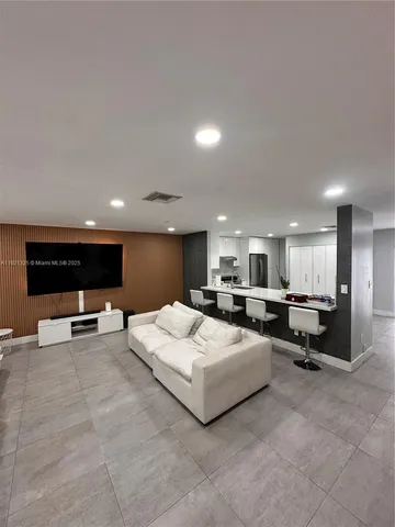 a living room with furniture a flat screen tv and a table