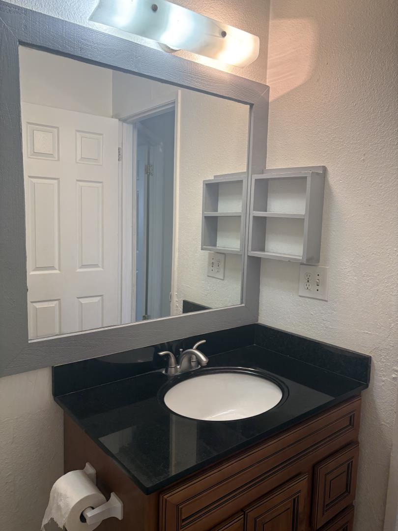 722 East Swain Road Stockton, CA 95207 - Photo 14 of 16 a bathroom with a sink and a mirror