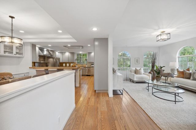 a kitchen with stainless steel appliances granite countertop sink stove refrigerator and cabinets