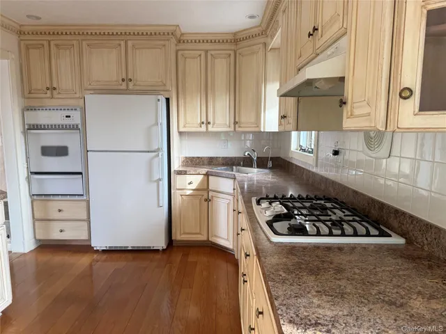 a kitchen with cabinets appliances and a wooden floor