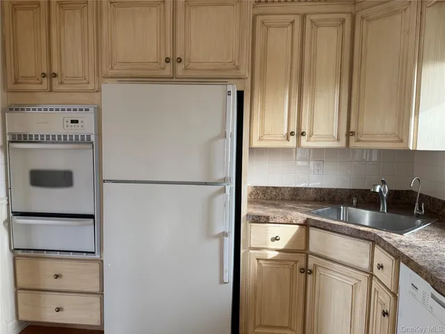 a kitchen with granite countertop a refrigerator and cabinets