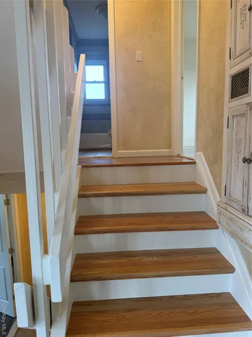 a view of staircase with white walls and a window
