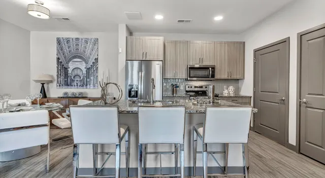 a kitchen with a dining table chairs refrigerator and cabinets