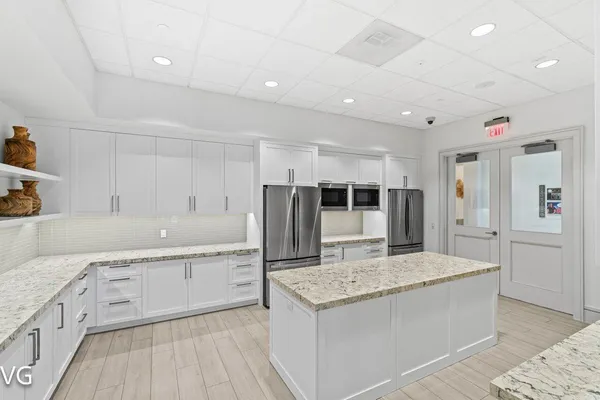 a large kitchen with kitchen island a sink stainless steel appliances and cabinets