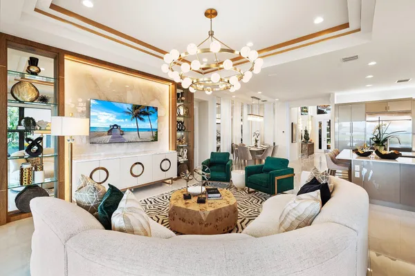 a living room with furniture a chandelier and a painting