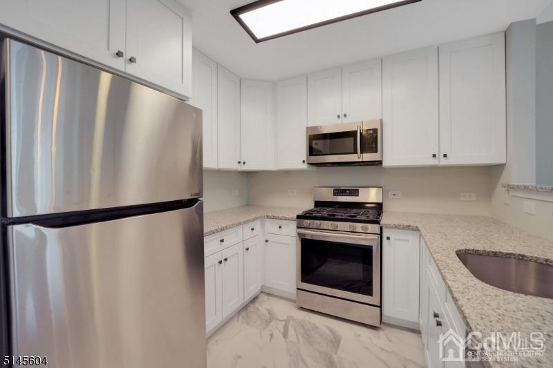 358 Rector Street, Unit 312 Perth Amboy, NJ 08861 - Photo 8 of 16 a kitchen with stainless steel appliances a refrigerator sink and cabinets