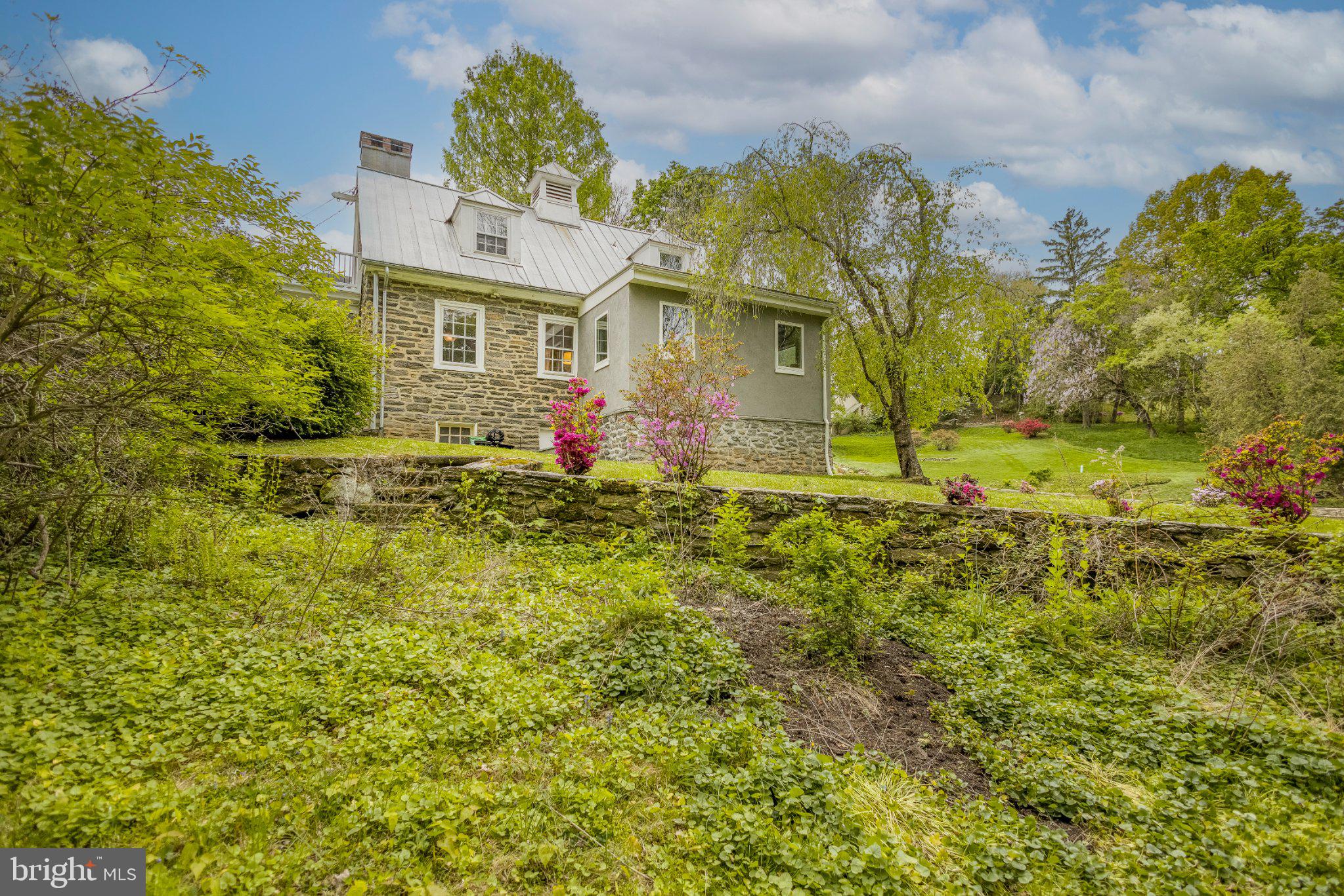 91 East Bells Mill Road Philadelphia, PA 19118 - Photo 29 of 29 Charming stone home amidst lush greenery.