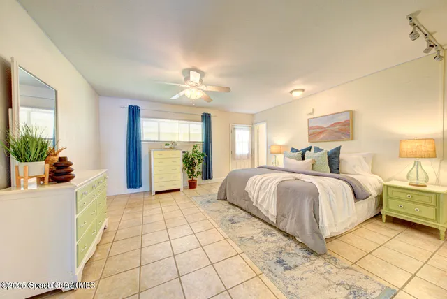 a spacious bedroom with a bed and a potted plant