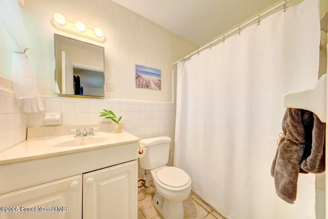 a bathroom with a sink a toilet and shower curtain