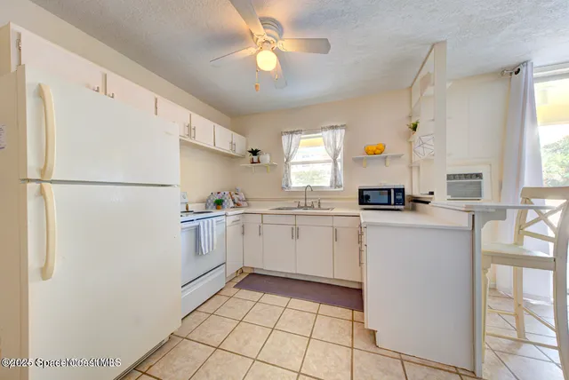a kitchen with a refrigerator a stove a sink and a window