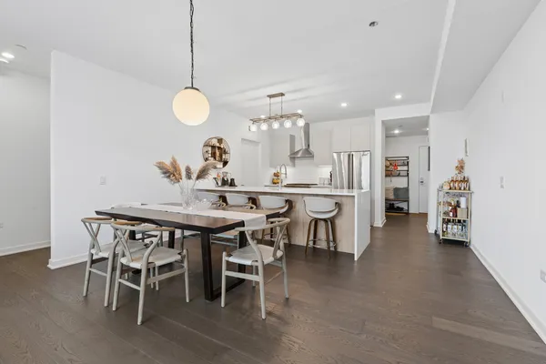 a dining room filled a chandelier and kitchen view