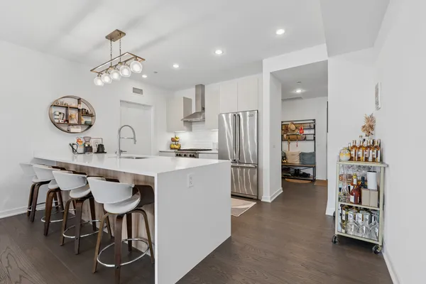 a kitchen with stainless steel appliances a table chairs and chandelier