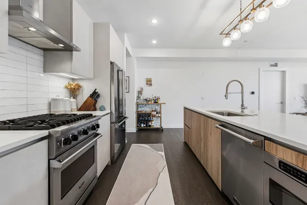 a kitchen with stainless steel appliances granite countertop a stove a sink and a refrigerator