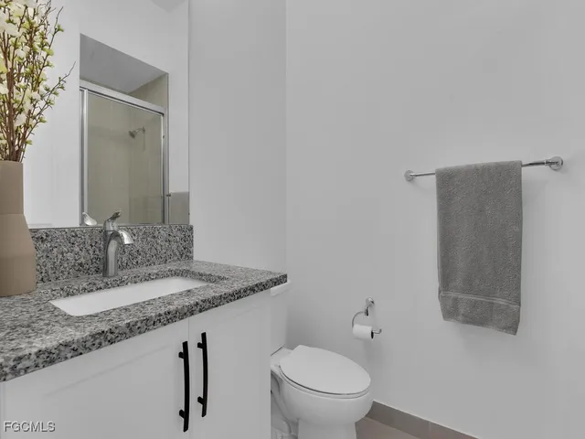 a bathroom with a granite countertop sink a toilet and bathtub