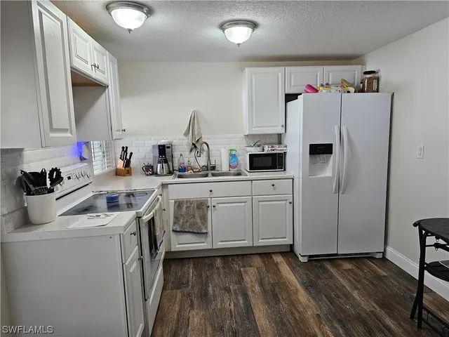 a kitchen that has a sink cabinets counter space and appliances