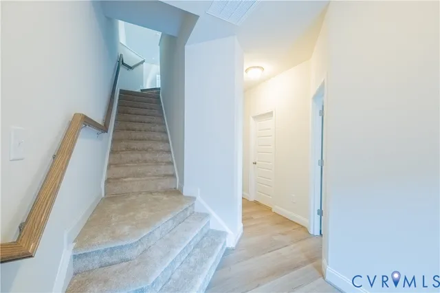a view of a hallway with wooden floor and entryway