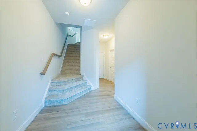 a view of a hallway with wooden floor and staircase