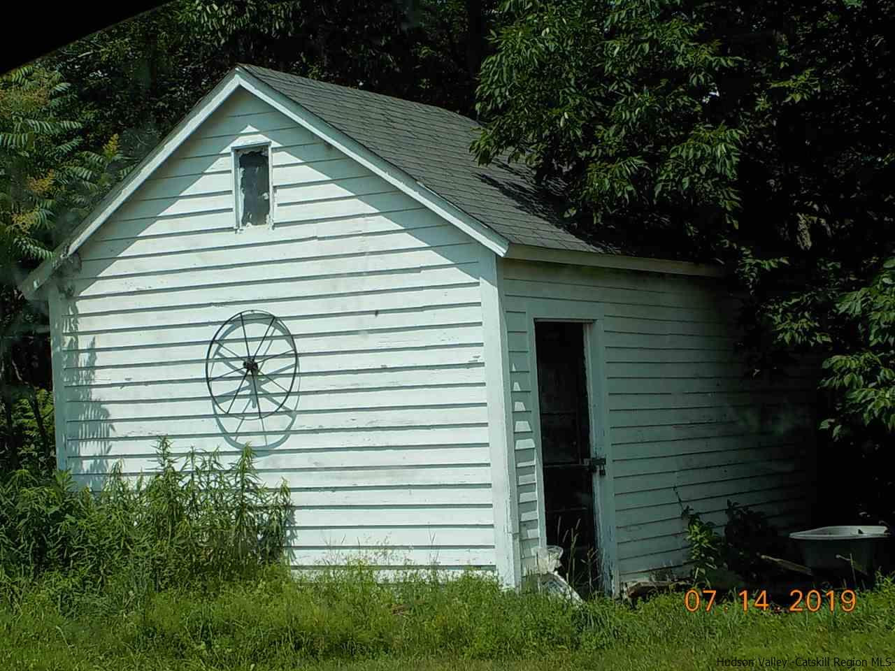2199 Burroughs Memorial Road Roxbury, NY 12474 - Photo 32 of 34 a small white house with a white roof and table and chairs next to window