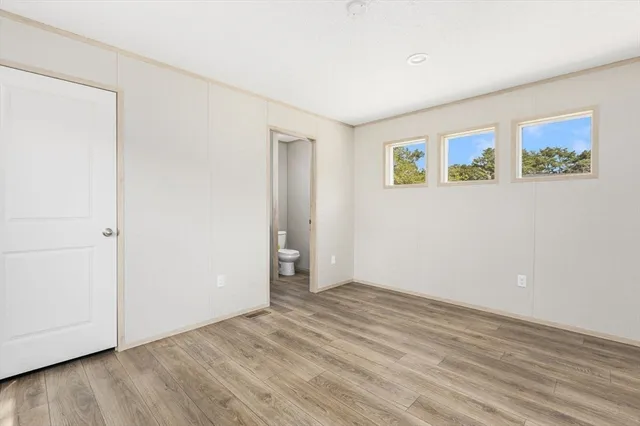 an empty room with wooden floor and window