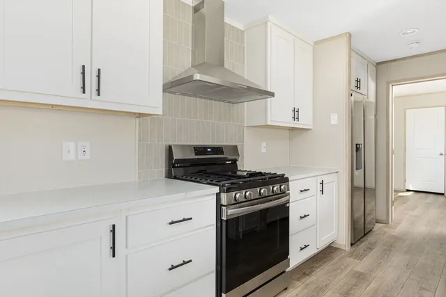 a kitchen with white cabinets and appliances