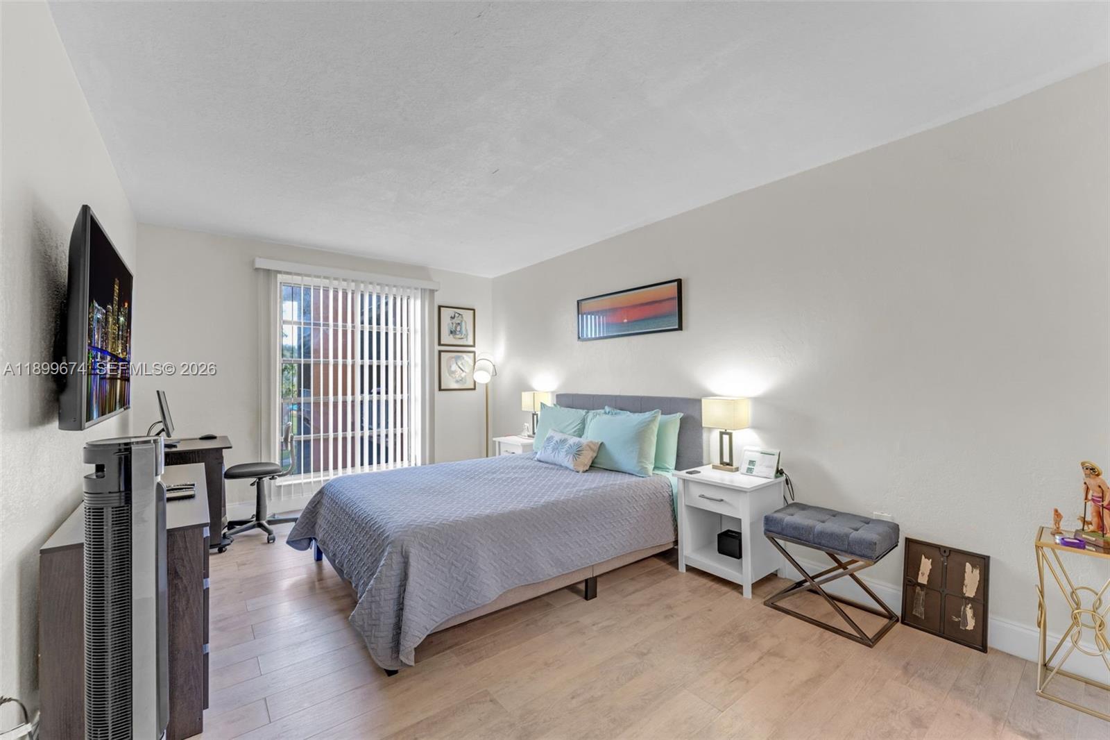 9437 Southwest 76th Street, Unit V25 Miami, FL 33173 - Photo 14 of 30 a bedroom with a bed a chair and a flat screen tv