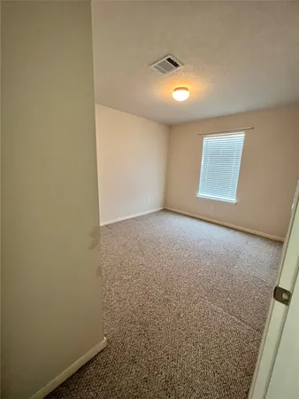 en empty room with windows and fan