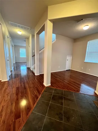 a room with pool table and wooden floor