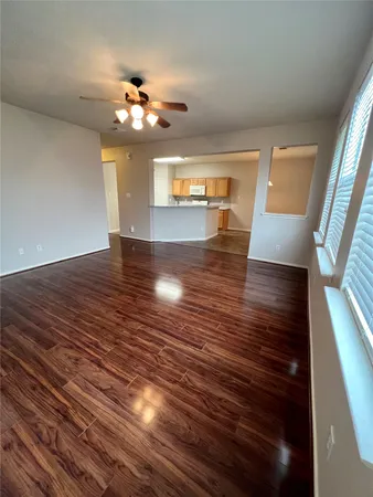a view of a livingroom with wooden floor and a ceiling fan
