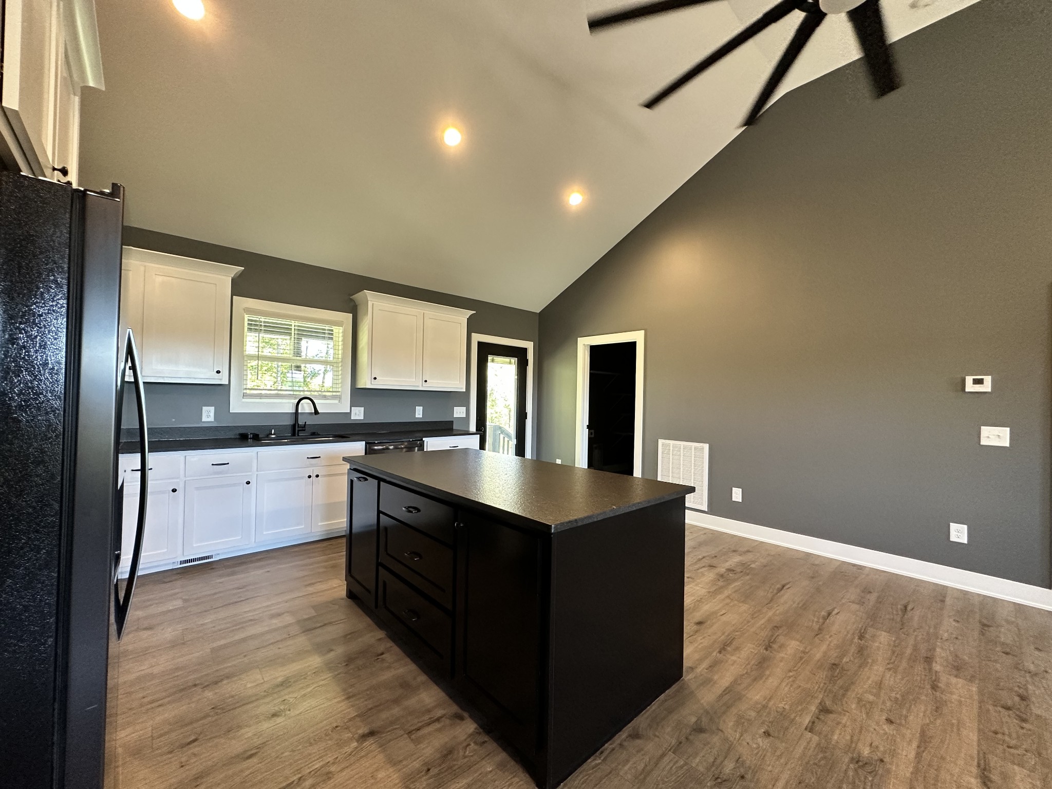 360 Coker Ford Road Portland, TN 37148 - Photo 29 of 46 a large kitchen with kitchen island a sink dishwasher a stove and refrigerator with wooden floor