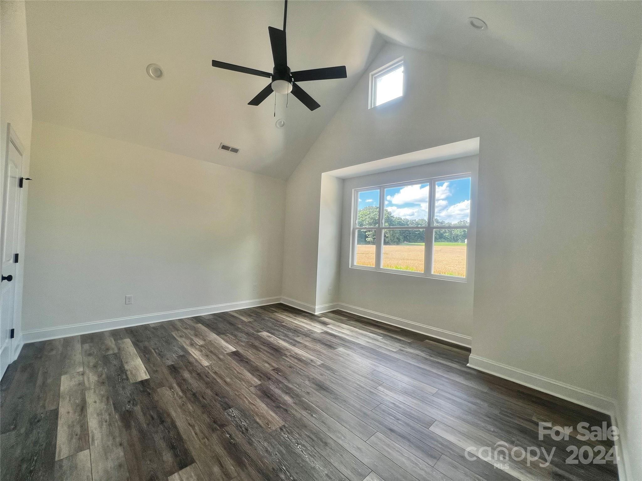 2709 Lathan Road Monroe, NC 28112 - Photo 13 of 26 a view of an empty room with a window and wooden floor