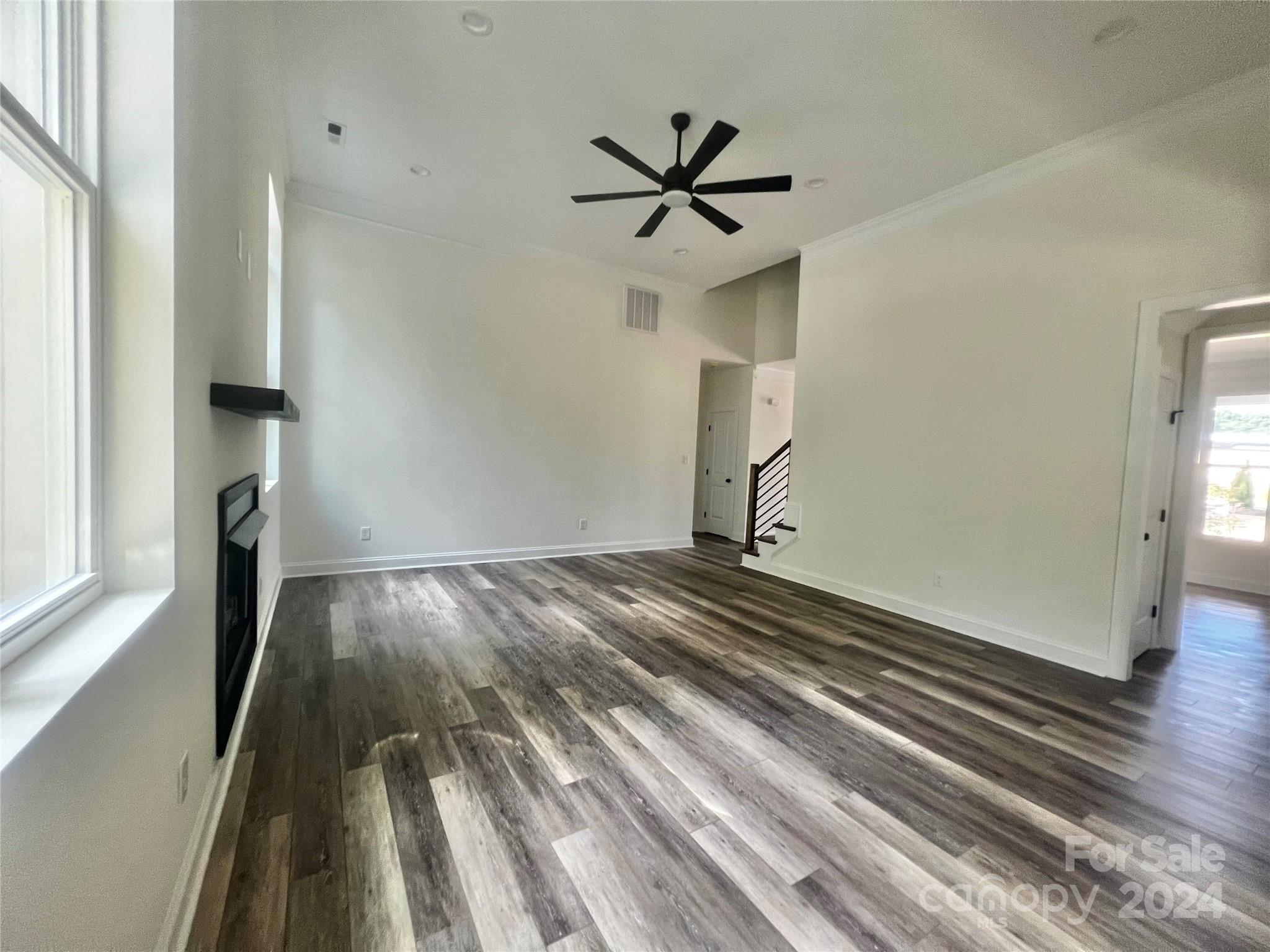 2709 Lathan Road Monroe, NC 28112 - Photo 19 of 26 a view of a livingroom with wooden floor and a ceiling fan