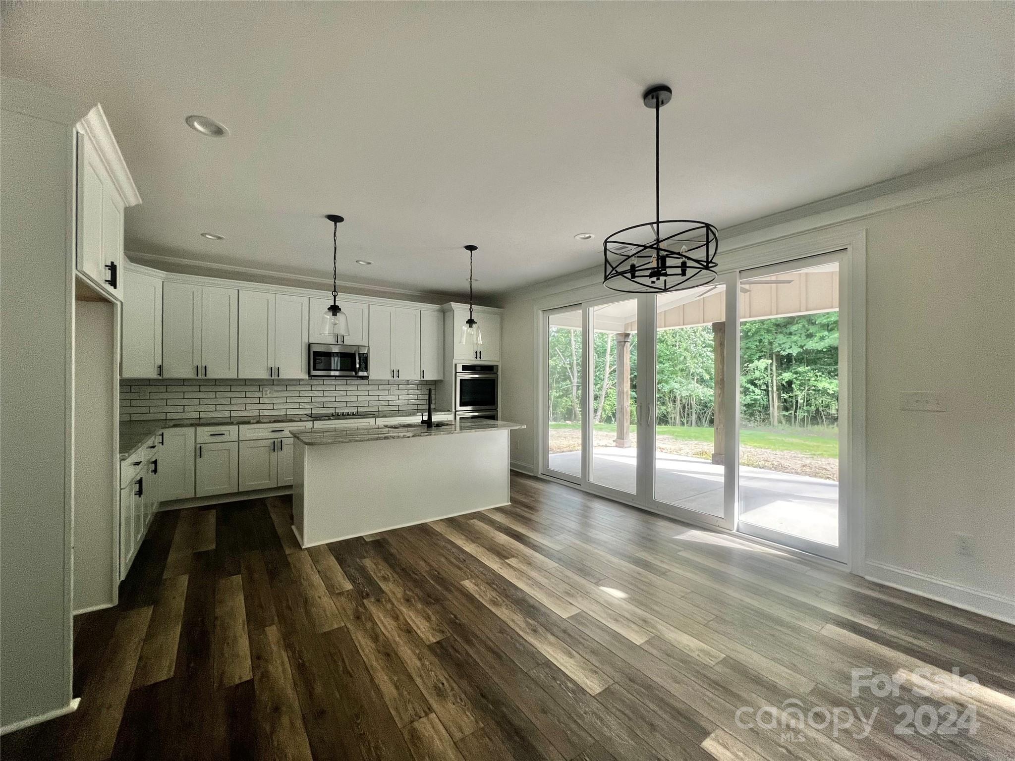 2709 Lathan Road Monroe, NC 28112 - Photo 5 of 26 a kitchen with kitchen island a large window appliances and cabinets