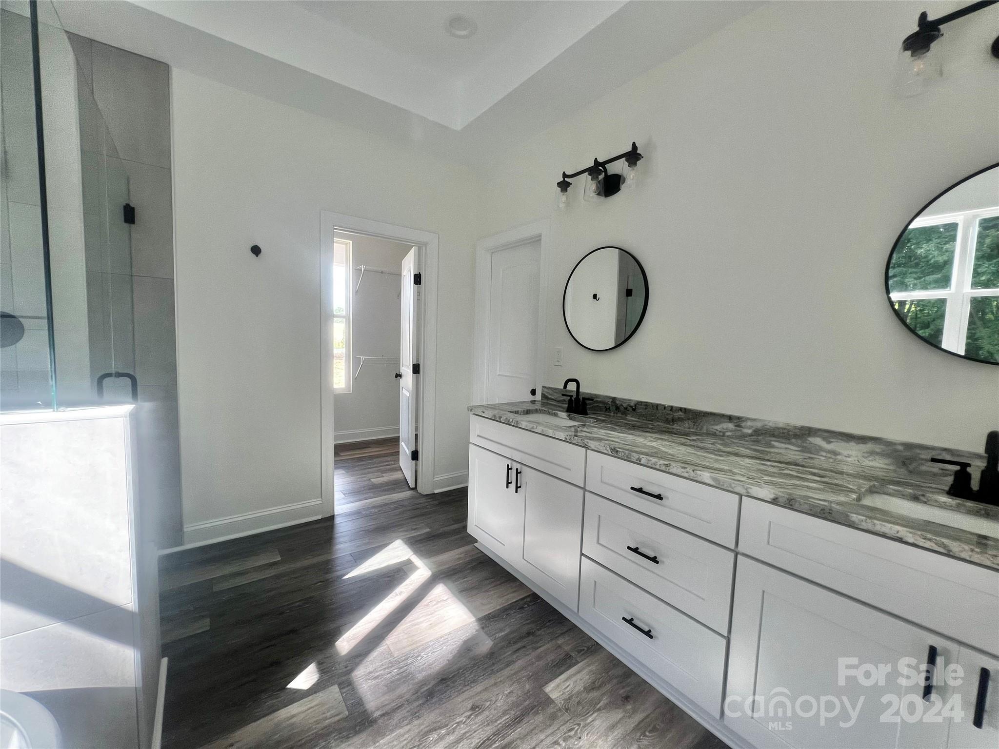 2709 Lathan Road Monroe, NC 28112 - Photo 8 of 26 a spacious bathroom with a granite countertop sink and a mirror
