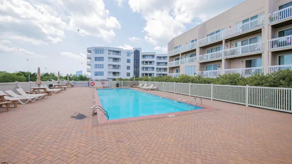 a view of a swimming pool with a lawn chairs and a yard