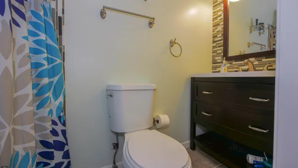 a bathroom with a toilet and a shower curtain
