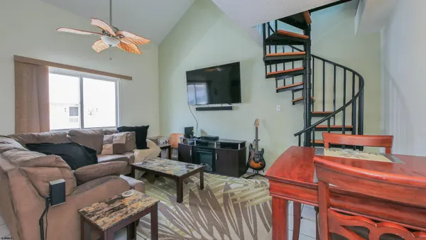 a living room with furniture a flat screen tv and a window
