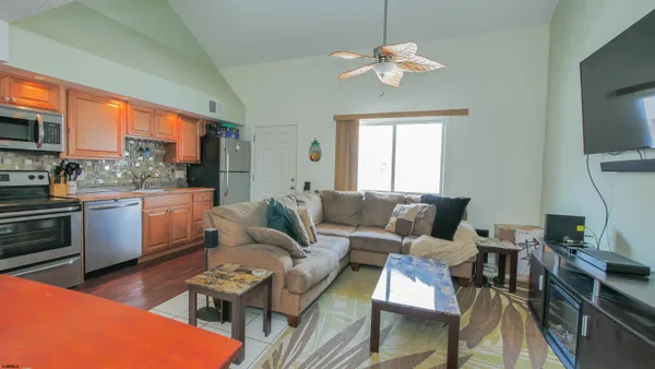 a living room with furniture a chandelier and a dining table