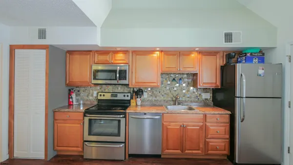 a kitchen with stainless steel appliances a refrigerator stove and cabinets