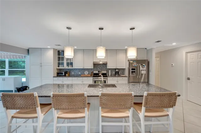a kitchen with a dining table chairs and refrigerator