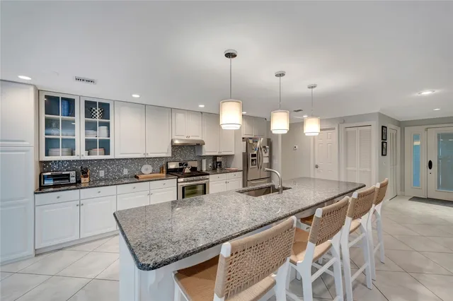 a kitchen with granite countertop a sink a counter top space appliances and cabinets