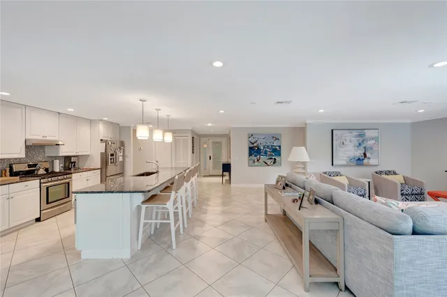 a living room with furniture and kitchen