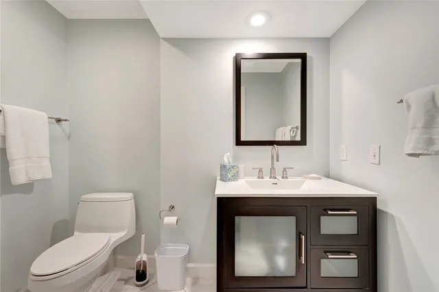 a bathroom with a toilet sink and mirror