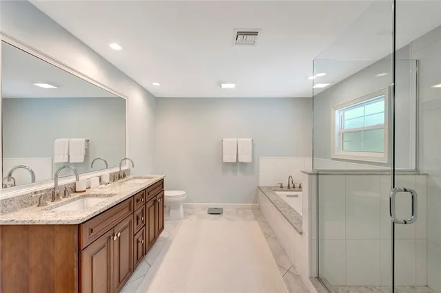 a bathroom with a double vanity sink a mirror and a bathtub